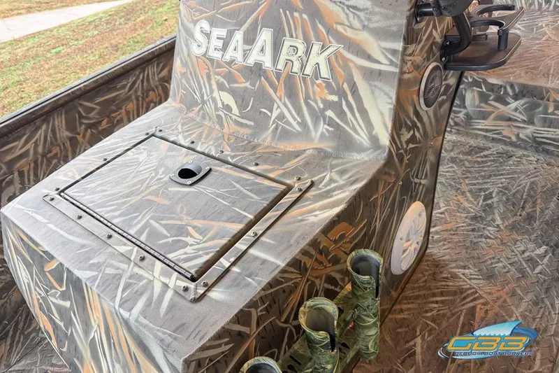 Slide: The Image of 2022 SeaArk 180 RXT boat with camouflage design, parked on a trailer. - 16