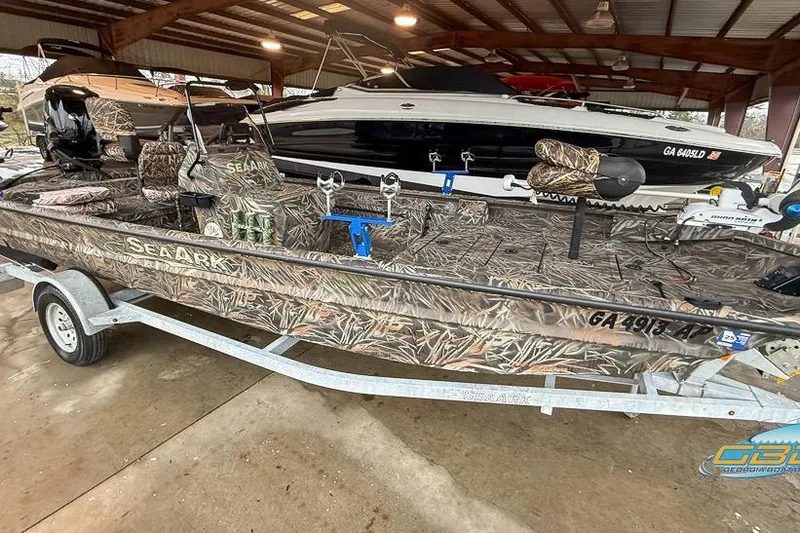 Slide: The Image of 2022 SeaArk 180 RXT boat with Mercury engine on trailer, camo design. - 2