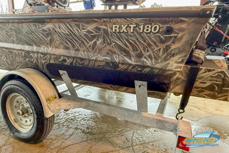 Slide: The Image of 2022 SeaArk 180 RXT boat with Mercury 90 engine, camo design, parked outdoors. - 24