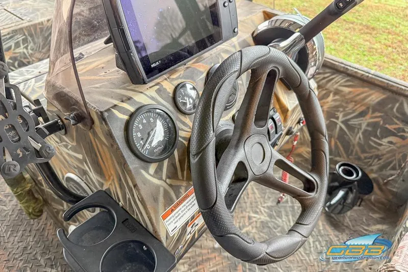 Slide: The Image of 2022 SeaArk 180 RXT boat with camouflage design on a trailer outside a building. - 4