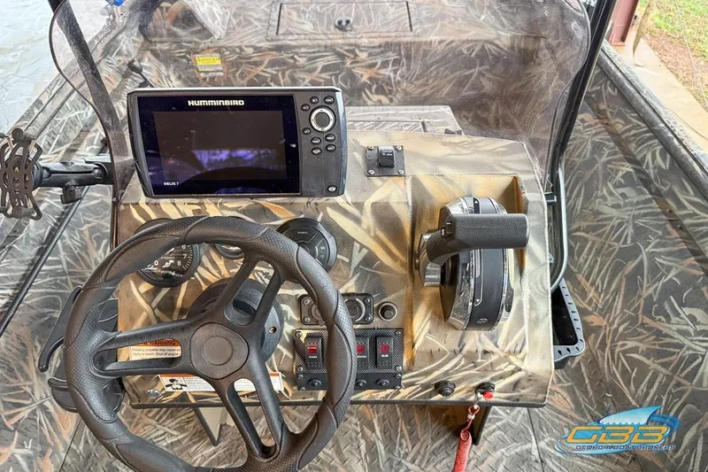 Slide: The Image of 2022 SeaArk 180 RXT boat with camouflage design on a trailer in a covered area. - 6