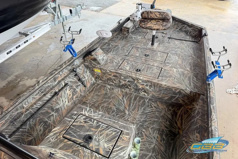 Slide: The Image of 2022 SeaArk 180 RXT boat interior with camouflage seating and storage compartments. - 7