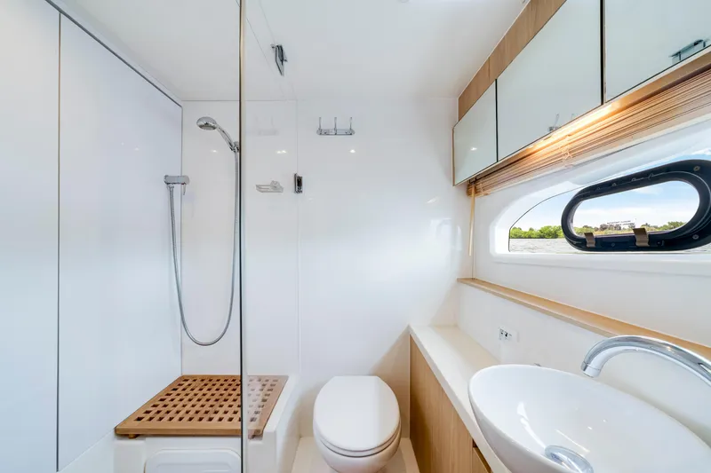 Slide: The Image of Luxurious bathroom on 2019 Aquila 44 Yacht with shower, sink, and window view. - 26