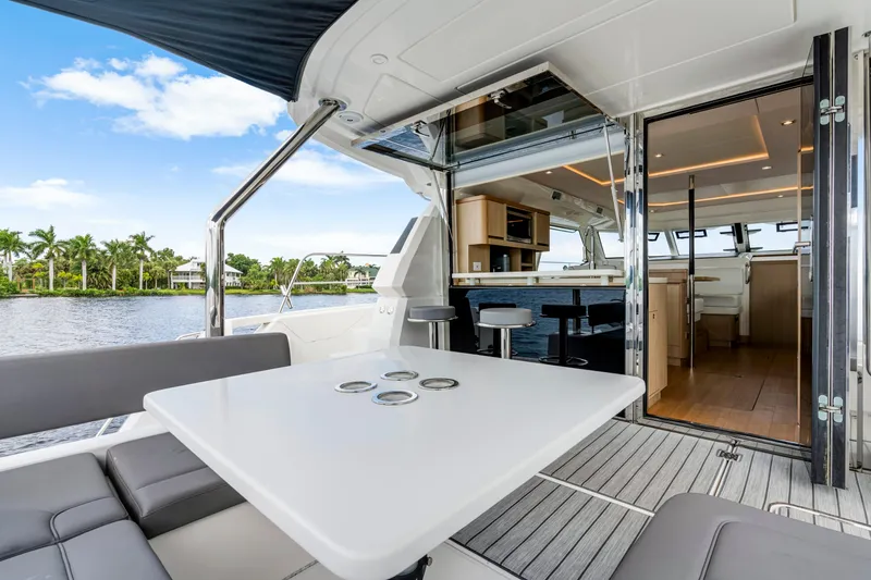 Slide: The Image of Luxurious 2019 Aquila 44 Yacht interior with modern seating and dining area, overlooking serene waters. - 38