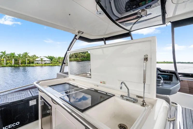 Slide: The Image of 2019 Aquila 44 Yacht kitchen area with sink and stove, overlooking serene waterway. - 49