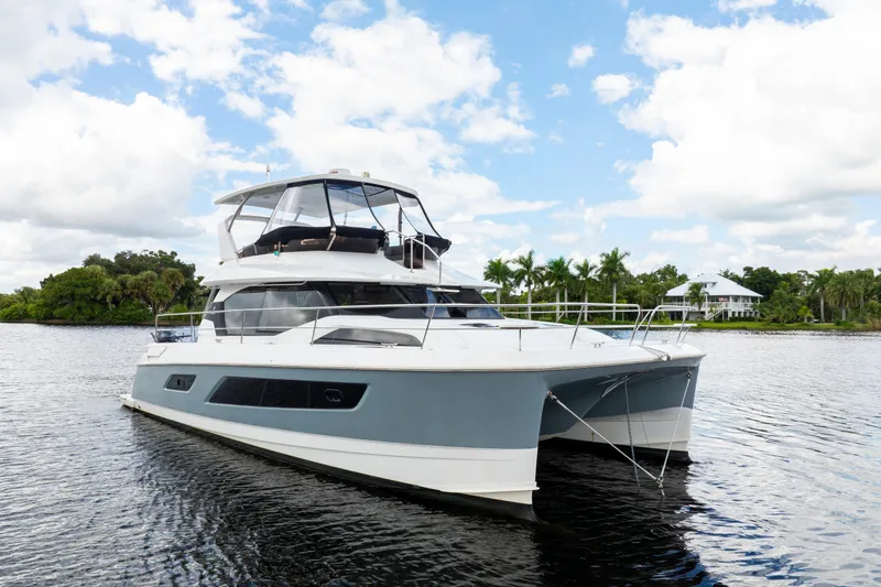 Slide: The Image of 2019 Aquila 44 Yacht on calm water with lush greenery and blue sky. - 58