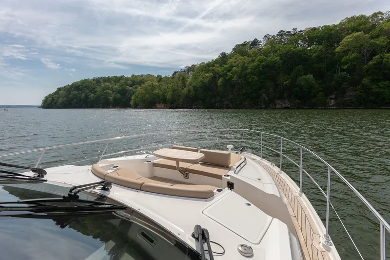 Slide: The Image of Sea Ray L650 Fly 2018 on calm waters with wooded shoreline. - 44