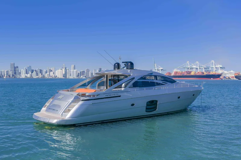 Slide: The Image of 2018 Pershing 70 yacht on water with city skyline and port cranes in background. - 1