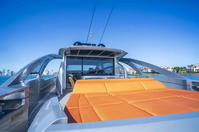 Slide: The Image of 2018 Pershing 70 yacht with orange seating, sleek design, and city skyline in the background. - 24
