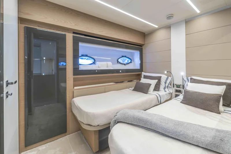 Slide: The Image of Luxurious 2018 Pershing 70 yacht bedroom with twin beds and modern decor. - 7