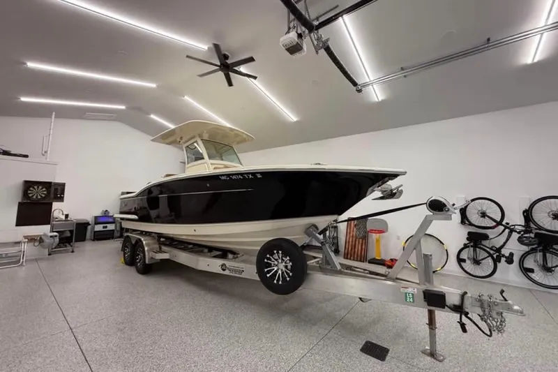 Slide: The Image of 2016 Scout 255 LXF boat on trailer in a spacious garage. - 11