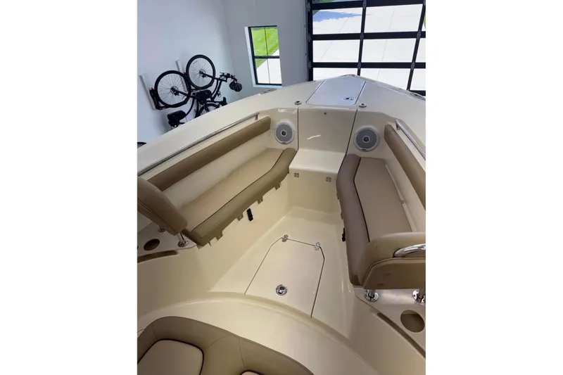 Slide: The Image of 2016 Scout 255 LXF boat interior with tan seating and built-in speakers. - 16