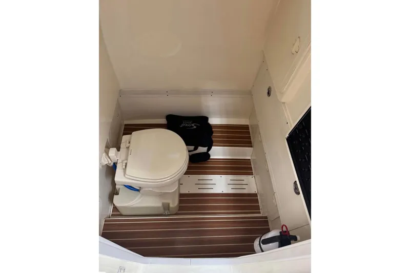 Slide: The Image of 2016 Scout 255 LXF boat interior with toilet and wooden flooring. - 17