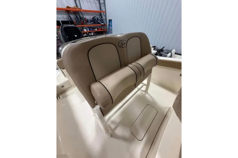 Slide: The Image of 2016 Scout 255 LXF boat seat with beige upholstery in a storage area. - 20