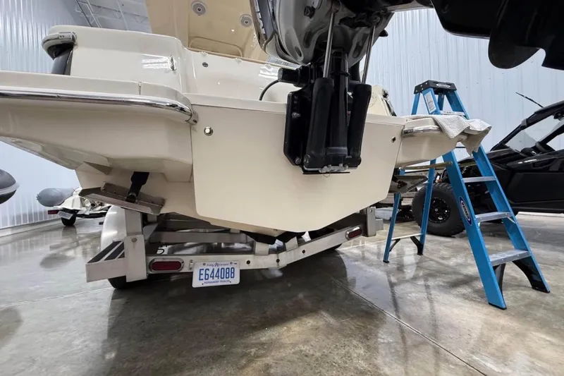Slide: The Image of 2016 Scout 255 LXF boat on trailer in garage with ladder nearby. - 25
