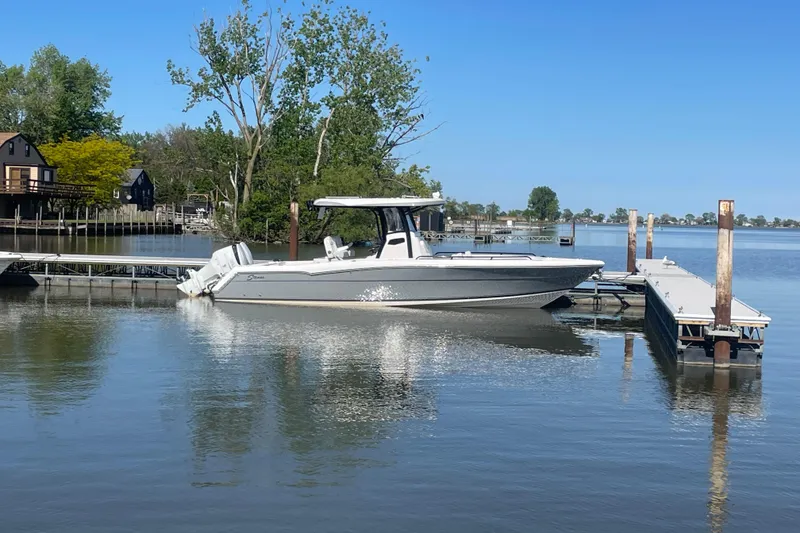 The Image of 2023 Stamas 31T Aventura boat docked on a calm lake with clear blue skies. - 0