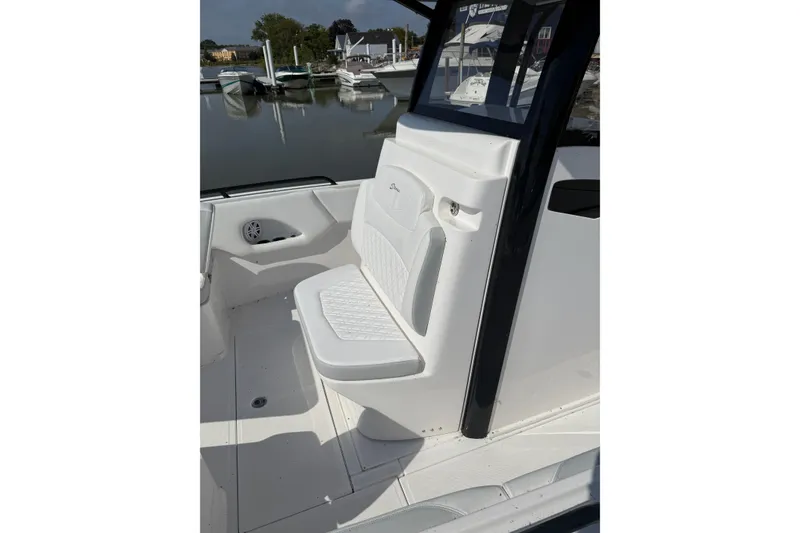 Slide: The Image of 2023 Stamas 31T Aventura boat interior with white seating and marina view. - 13