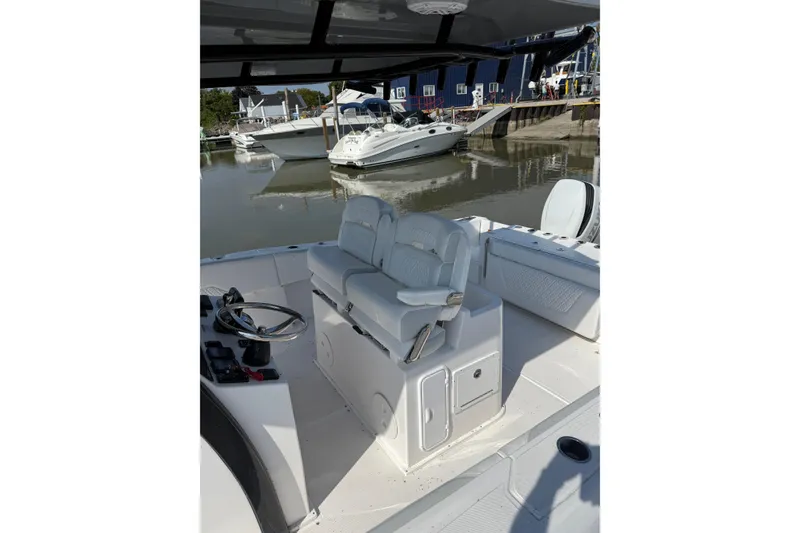 Slide: The Image of 2023 Stamas 31T Aventura boat interior with helm and seating at marina. - 14