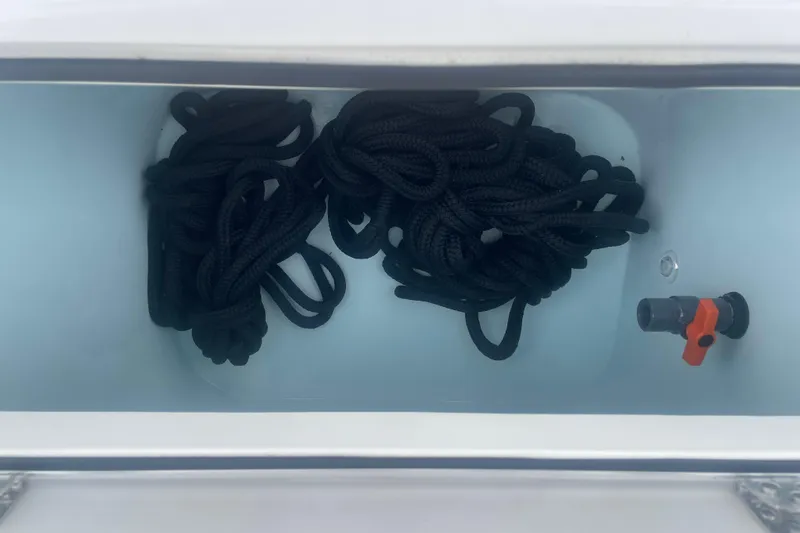 Slide: The Image of Storage compartment with black ropes in a 2023 Stamas 31T Aventura boat. - 32