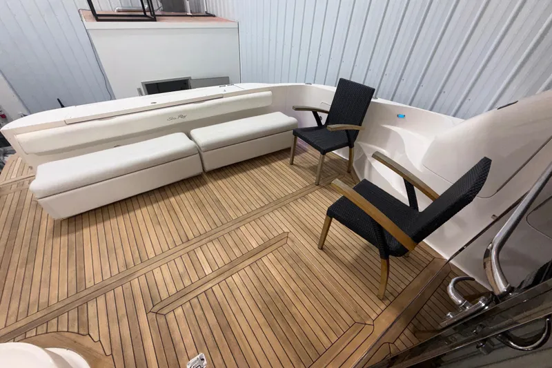 Slide: The Image of 2001 Sea Ray 560 Sedan Bridge yacht deck with seating and wooden flooring. - 14