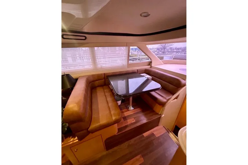 Slide: The Image of Luxurious interior of 2001 Sea Ray 560 Sedan Bridge with plush seating and elegant table. - 26