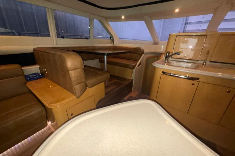 Slide: The Image of Luxurious interior of 2001 Sea Ray 560 Sedan Bridge yacht with seating and kitchenette. - 28