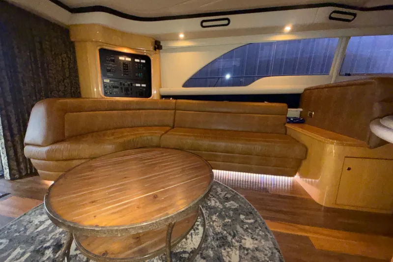 Slide: The Image of Luxurious interior of 2001 Sea Ray 560 Sedan Bridge with leather seating and wooden table. - 30