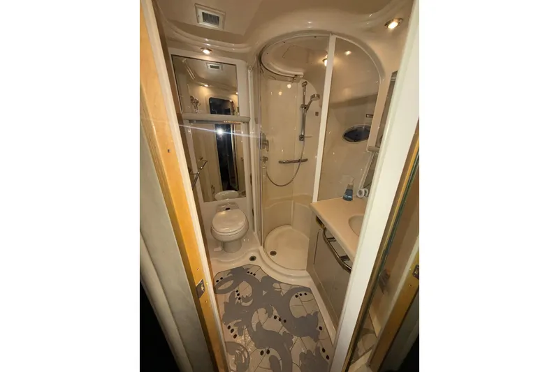 Slide: The Image of Compact bathroom in 2001 Sea Ray 560 Sedan Bridge yacht, featuring shower, toilet, and sink. - 44