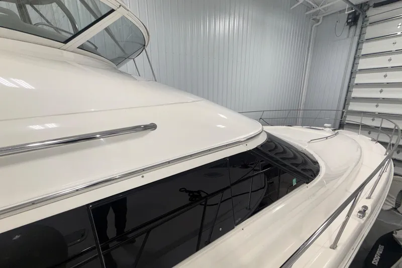 Slide: The Image of 2001 Sea Ray 560 Sedan Bridge yacht in a storage facility, showcasing sleek design and polished finish. - 6