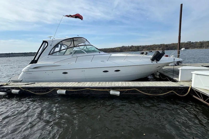 The Image of 2003 Cruisers Yachts 4370 Express docked on a calm lake under a clear sky. - 0