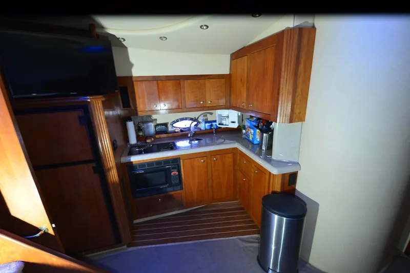 Slide: The Image of 2003 Cruisers Yachts 4370 Express kitchen with wooden cabinets and modern appliances. - 14