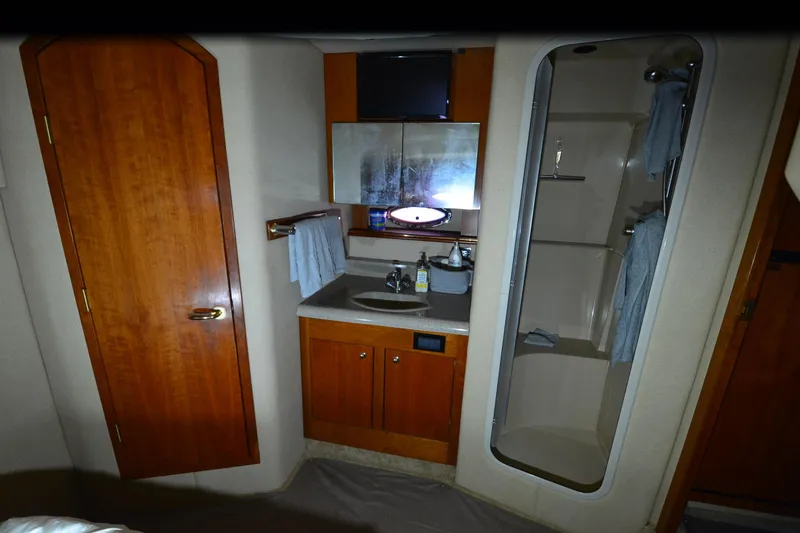 Slide: The Image of 2003 Cruisers Yachts 4370 Express bathroom with shower, sink, and wooden cabinetry. - 16
