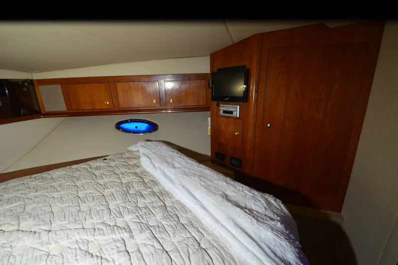 Slide: The Image of Interior cabin of 2003 Cruisers Yachts 4370 Express with wood paneling and bedding. - 23