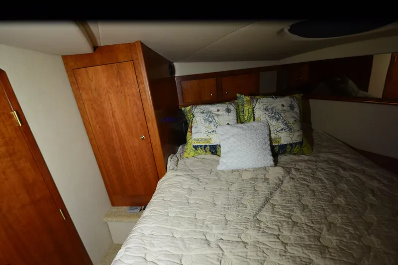 Slide: The Image of Cozy bedroom interior of 2003 Cruisers Yachts 4370 Express with wooden cabinetry and plush bedding. - 24