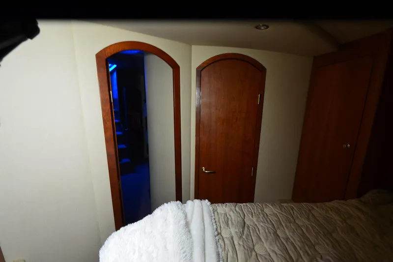 Slide: The Image of Interior of 2003 Cruisers Yachts 4370 Express with wooden doors and cozy bedding. - 25