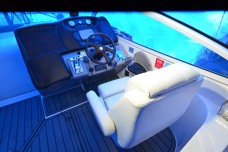 Slide: The Image of Cockpit of 2003 Cruisers Yachts 4370 Express with white leather seat and wooden steering wheel. - 27