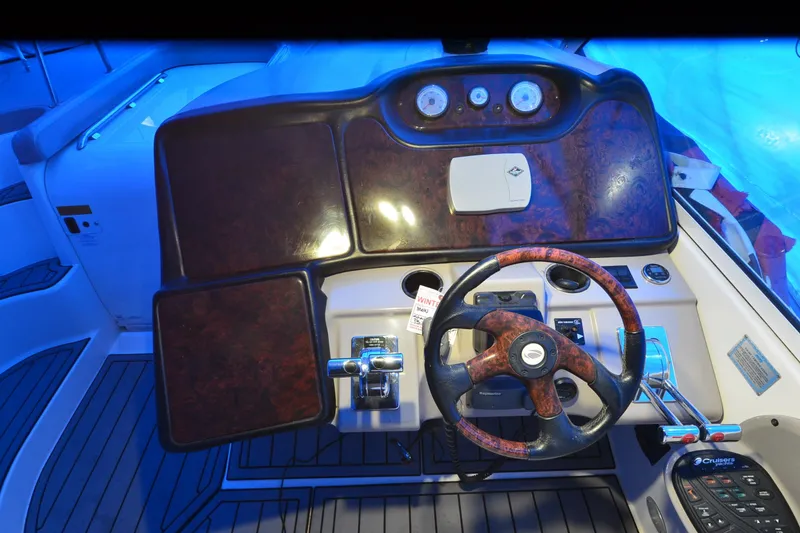 Slide: The Image of 2003 Cruisers Yachts 4370 Express helm with wood accents and modern controls. - 29