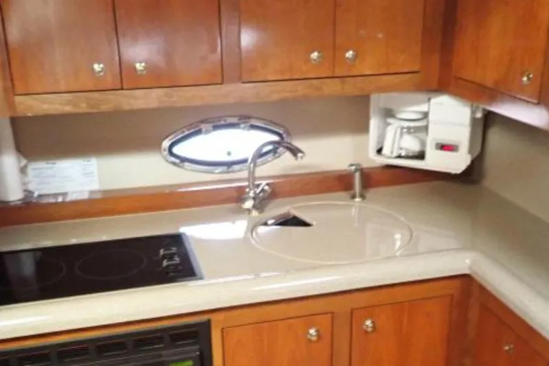Slide: The Image of 2003 Cruisers Yachts 4370 Express kitchen with wooden cabinets and modern appliances. - 5