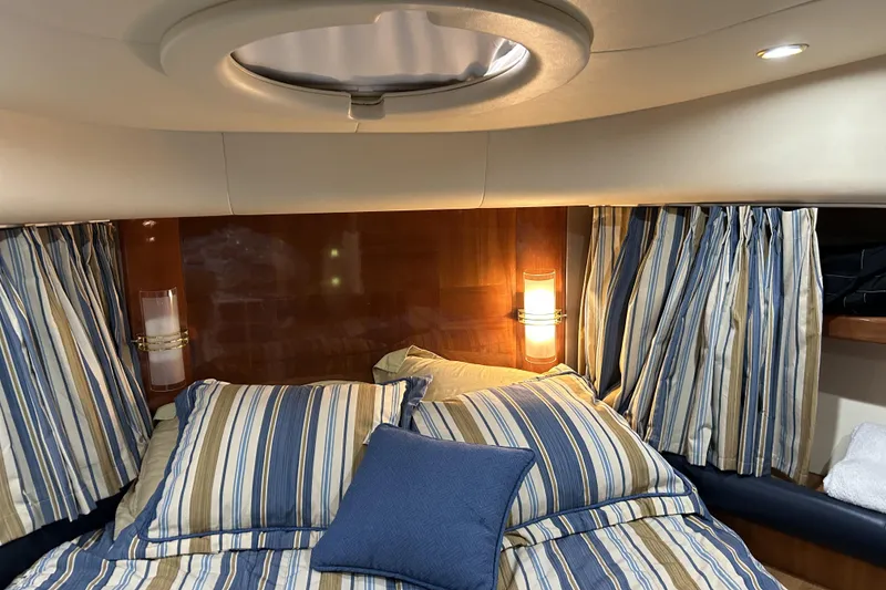 Slide: The Image of Luxurious cabin interior of a 2003 Azimut 55 yacht with striped bedding and ambient lighting. - 19