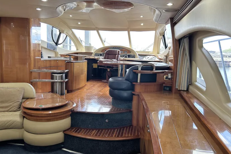 Slide: The Image of Luxurious interior of a 2003 Azimut 55 yacht with elegant wood finishes and plush seating. - 2