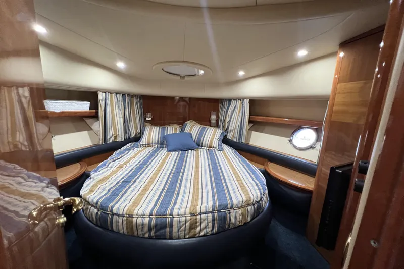 Slide: The Image of Luxurious cabin interior of a 2003 Azimut 55 yacht with striped bedding and wood accents. - 20