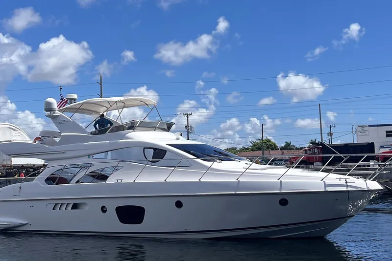 Slide: The Image of 2003 Azimut 55 yacht on water under blue sky with clouds. - 23