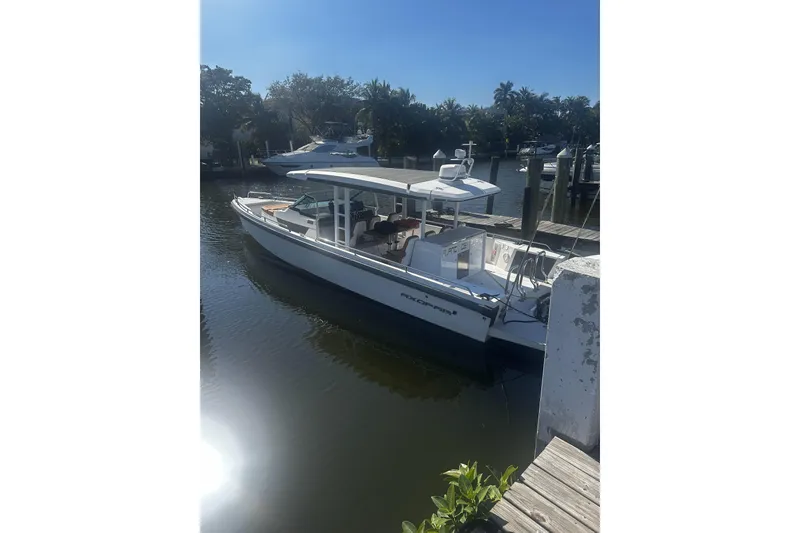 The Image of 2018 Axopar 37 Sun-Top boat docked in a sunny marina setting. - 0