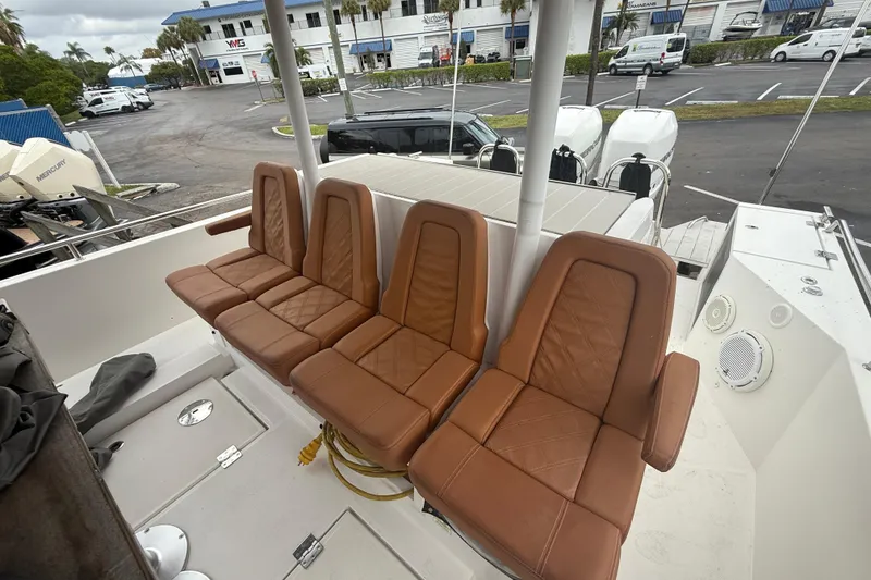 Slide: The Image of 2018 Axopar 37 Sun-Top boat with brown leather seats and outdoor setting. - 11