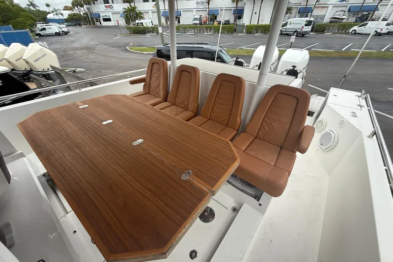 Slide: The Image of 2018 Axopar 37 Sun-Top boat with brown leather seats and wooden table. - 15