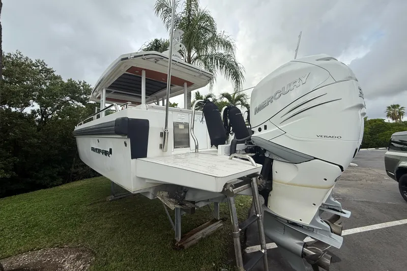 Slide: The Image of 2018 Axopar 37 Sun-Top boat with Mercury Verado engines, parked on grass. - 17