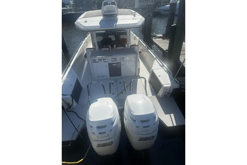 Slide: The Image of 2018 Axopar 37 Sun-Top boat with twin 350 Verado engines docked at marina. - 3