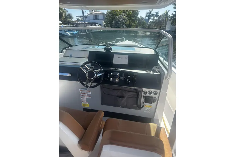 Slide: The Image of 2018 Axopar 37 Sun-Top boat with Mercury engine, displayed outdoors near palm trees. - 5