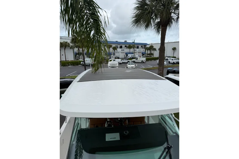 Slide: The Image of 2018 Axopar 37 Sun-Top boat with Garmin equipment, parked near palm trees. - 9