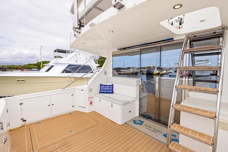Slide: The Image of 2023 ArrowCat 420 Flybridge yacht with teak deck, seating, and ladder in marina setting. - 20